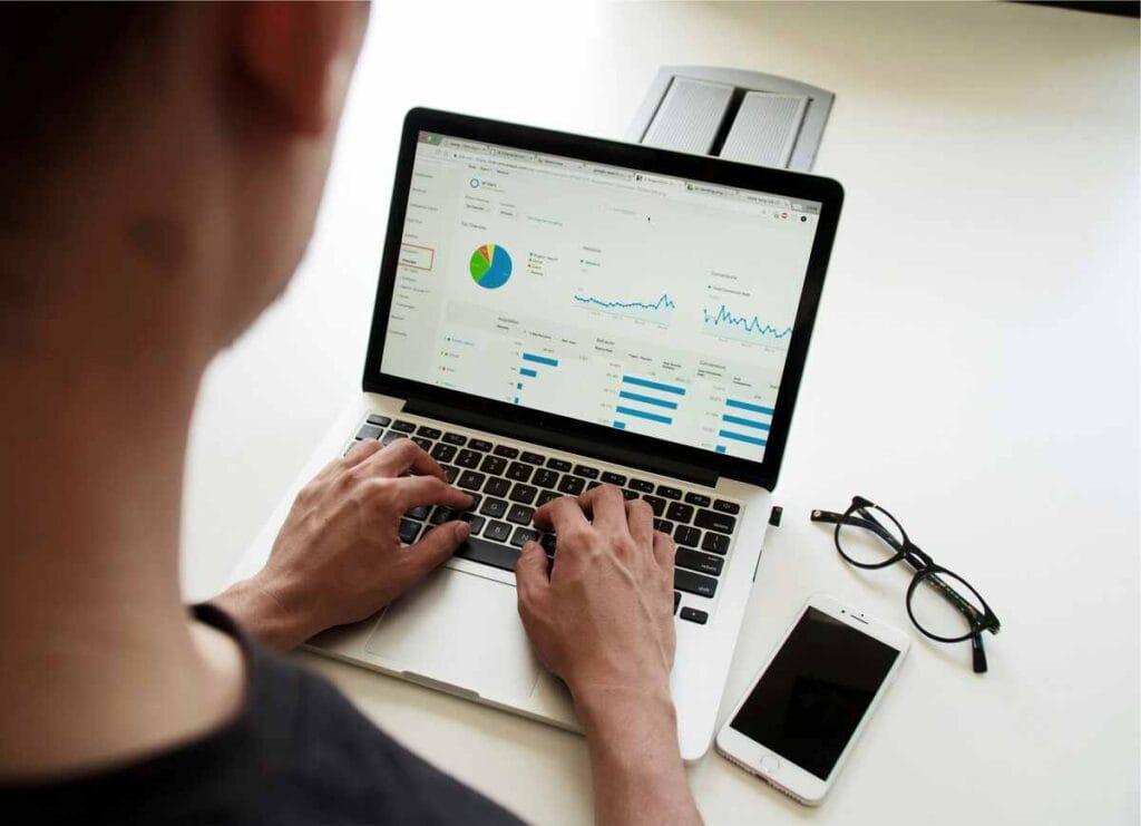 Small business owner reviewing outsourced payroll reports on laptop