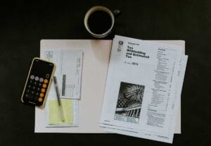 UK payroll tax documents and calculator on a small business owner's desk