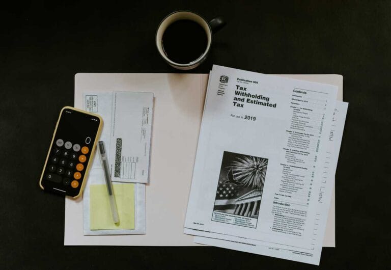 UK payroll tax documents and calculator on a small business owner's desk